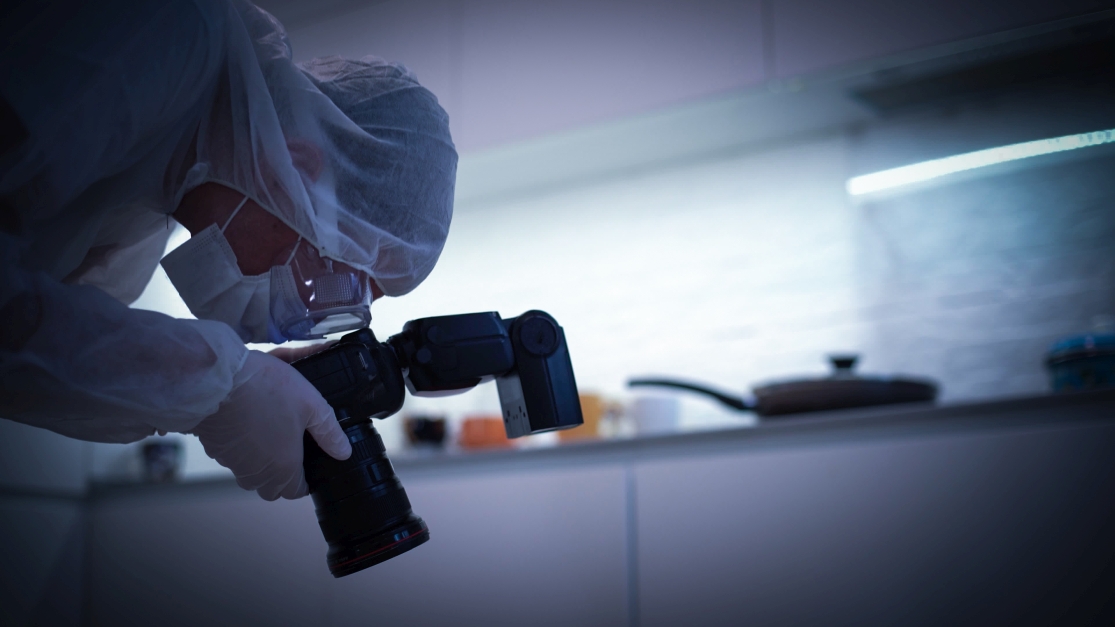 Ein Forensiker fotografiert Tatortspuren ab.