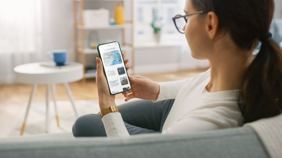 eine Frau liest die Nachrichten auf dem Handy