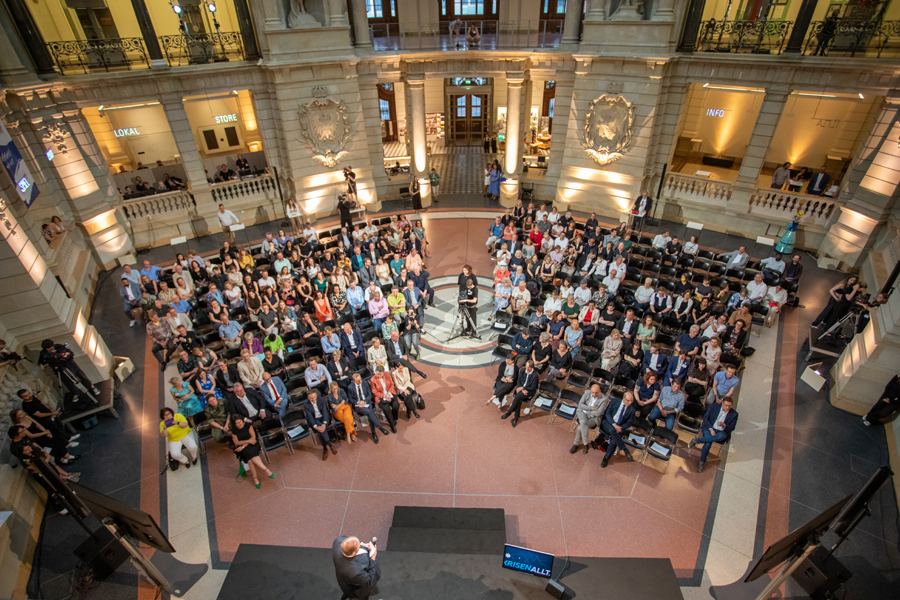 Blick von oben auf Zuschauerinnen und Zuschauer in einem festlichen Saal