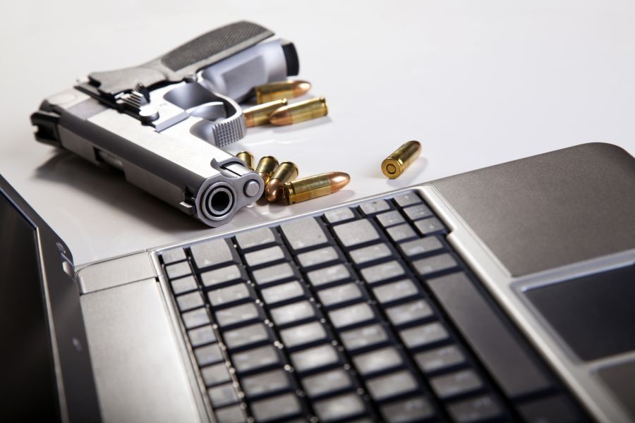 Laptoptastatur und eine Pistole