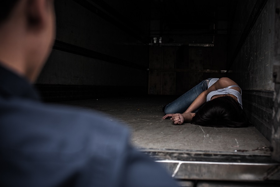 Eine im Track liegende Frau mit gebundenen Händen