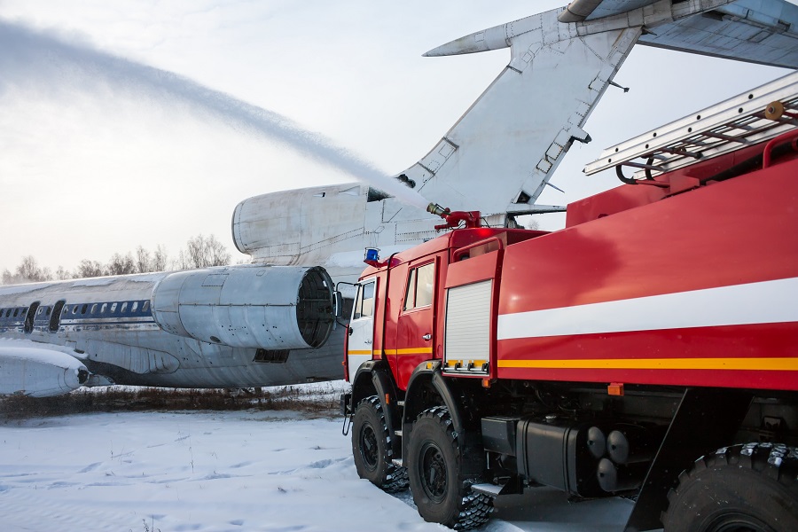 Feuerwehrauto löscht ein brennendes Flugzeug