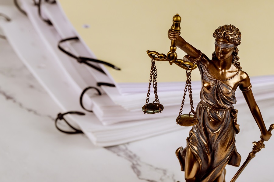 Ein Justitia-Statue und eine Stapel von Mappen